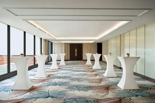 a corridor with tables and chairs in a room with windows at Renaissance Danang Hoi An Resort & Spa in Hoi An