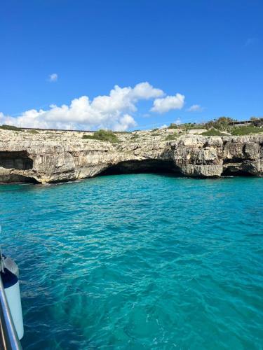 a boat in front of a cave in the water at Il Posticino di Tiggiano in Tiggiano