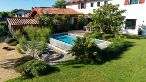 a backyard with a swimming pool and a house at Villa Loreteian - Splendide villa au calme in Ahetze
