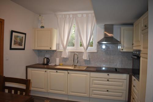 a kitchen with white cabinets and a sink and a window at CoCo Villa in Makarska