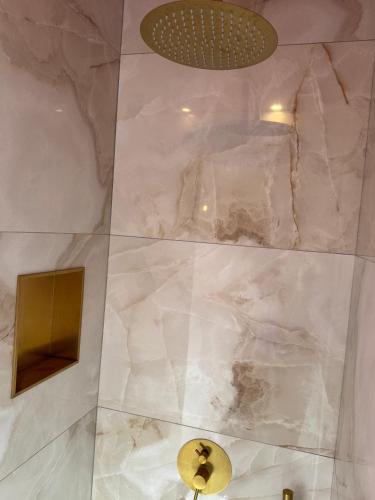 a shower with white marble walls and a ceiling at Add'Or, Suite et Spa in Beugny