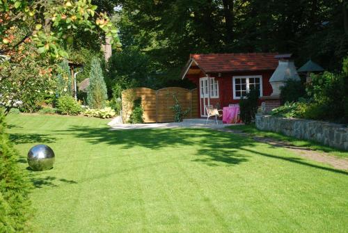 a yard with a garden with a house and a fence at Haus Elisabeth, Appartements in Krumpendorf am Wörthersee