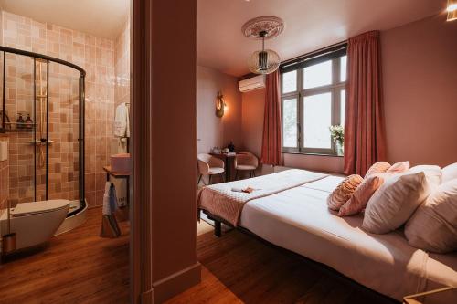 a bedroom with a large bed and a bathroom at B&B het Notarishuis - authentiek verblijf nabij Maastricht in Voeren
