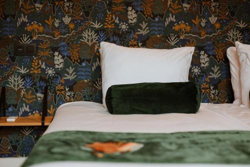 a bedroom with a bed with a black and white pillow at B&B het Notarishuis - authentiek verblijf nabij Maastricht in Voeren