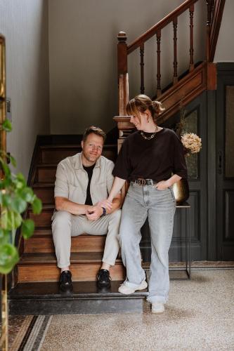 a man and a woman sitting on the stairs at B&B het Notarishuis - authentiek verblijf nabij Maastricht in Voeren