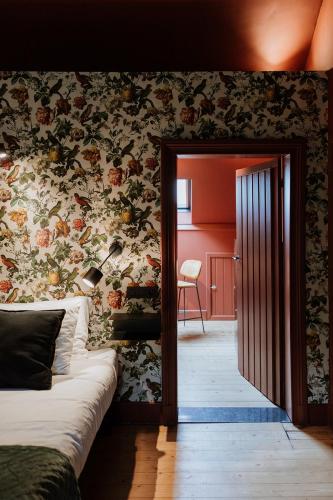 a bedroom with a bed and a floral wall at B&B het Notarishuis - authentiek verblijf nabij Maastricht in Voeren