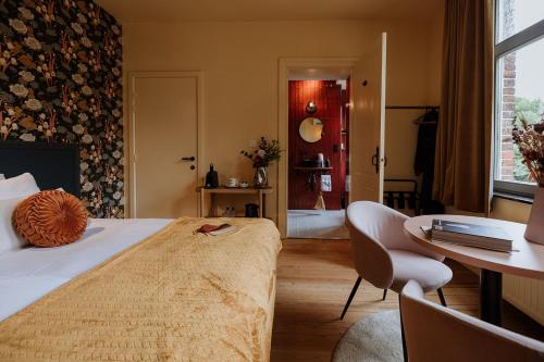 a bedroom with a bed and a desk and a table at B&B het Notarishuis - authentiek verblijf nabij Maastricht in Voeren