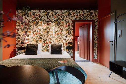 a bedroom with a bed with a floral wall at B&B het Notarishuis - authentiek verblijf nabij Maastricht in Voeren