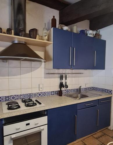 a kitchen with blue cabinets and a sink at Dans la Cité de Rocamadour L'Oustal de Beline in Rocamadour