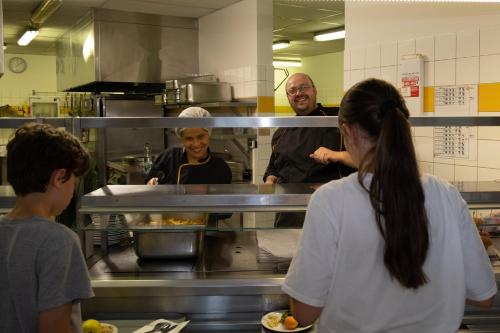 a group of people in a kitchen preparing food at Auberge de Jeunesse HI Strasbourg 2 Rives in Strasbourg