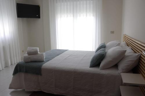 a bedroom with a bed with pillows and a window at Hotel Alejandrina Poio in Poio