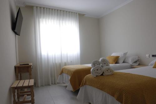 a bedroom with two beds with towels on them at Hotel Alejandrina Poio in Poio