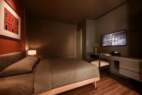 a bedroom with a bed and a desk and a television at Express by M Village Nguyễn Bỉnh Khiêm in Ho Chi Minh City