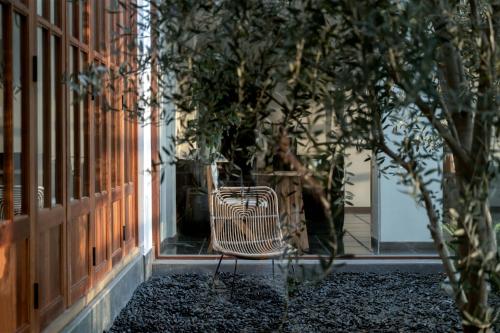 a bench sitting outside of a building with a tree at Dali Qingmai Seaview Resort in Dali