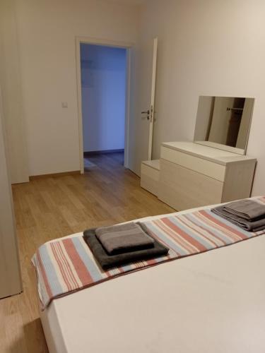 a bedroom with a bed with a dresser and a mirror at Comfort hillside in Pristina