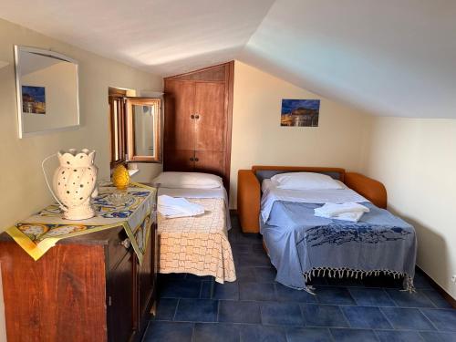a small bedroom with two beds and a table at MiraMare Residence Cefalú in Cefalù
