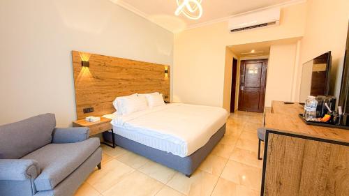 a hotel room with a bed and a couch at Aqaba Gulf Hotel By FHM in Aqaba