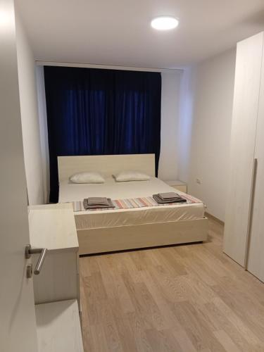 a bedroom with a bed and a blue curtain at Comfort hillside in Pristina