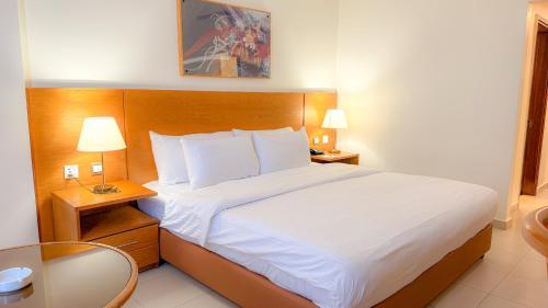 a hotel room with a bed and two lamps and a table at Aqaba Gulf Hotel By FHM in Aqaba