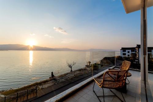 a balcony with two chairs and a view of the water at Dali Qingmai Seaview Resort in Dali