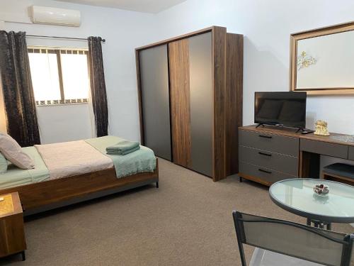 a bedroom with a bed and a tv and a table at Sea Breeze Retreat - Comfort Apartments in the Heart of Sliema in Sliema