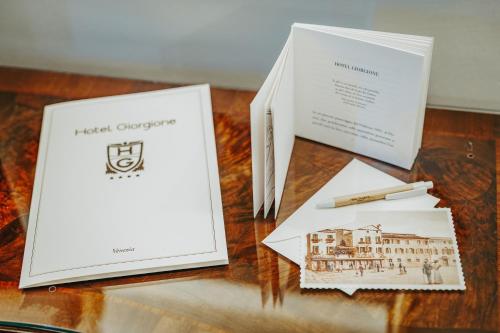 two books sitting on a table with a pen at Hotel Giorgione in Venice