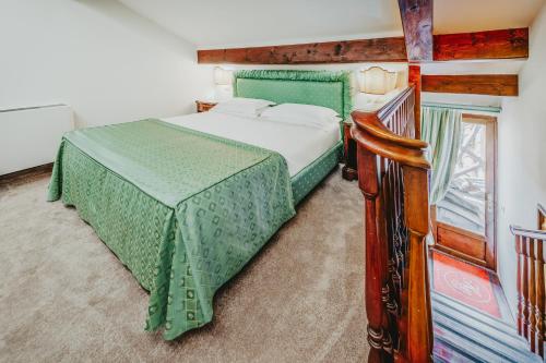 a bedroom with a bed and a wooden staircase at Hotel Giorgione in Venice