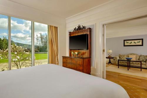 a bedroom with a bed and a large window at Powerscourt Hotel, Autograph Collection in Enniskerry