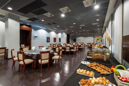 a dining room with tables and chairs and food at Hotel Diagonal Plaza in Zaragoza