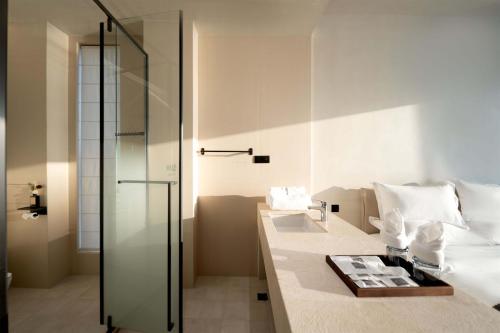 a bathroom with a glass shower and a bed at Dali Qingmai Seaview Resort in Dali
