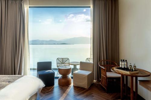 a bedroom with a large window with a view of the water at Dali Qingmai Seaview Resort in Dali