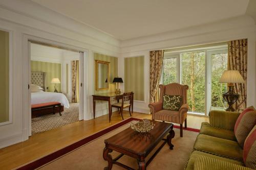 a hotel room with a bed and a living room at Powerscourt Hotel, Autograph Collection in Enniskerry