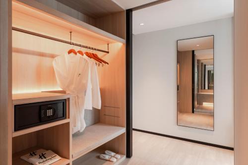 a dressing room with a mirror and a closet at Holiday Inn Kuala Lumpur Bangsar by IHG in Kuala Lumpur