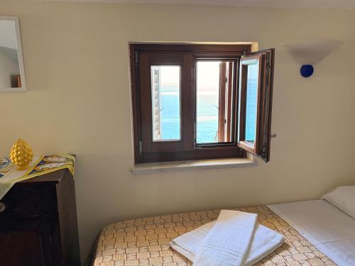 a bedroom with a bed and a window at MiraMare Residence Cefalú in Cefalù