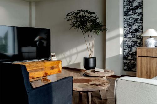 a living room with a tv and a couch and a table at Dali Qingmai Seaview Resort in Dali
