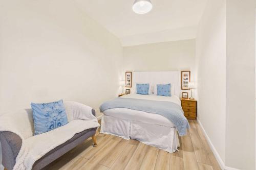 a white bedroom with a bed and a chair at Host & Stay - Lane Farm Cottage in Easington