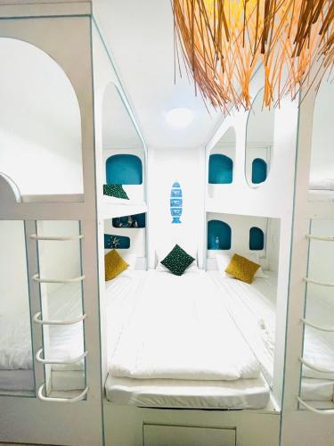 a bedroom with a white bunk bed with blue accents at Homestay mon house quy nhơn-phòng in Quy Nhon