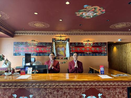 two men standing behind a bar in a restaurant at Gakhil Boutique Hotel in Darjeeling