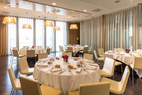 a banquet room with tables and chairs with white tablecloths at Hotel Diagonal Plaza in Zaragoza