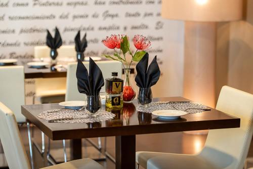 a dining room table with vases and flowers on it at Hotel Diagonal Plaza in Zaragoza