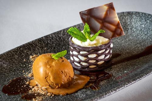 a plate with a chocolate dessert and a desert with mint at Hotel Diagonal Plaza in Zaragoza