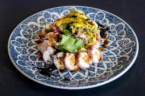 a plate of food with shrimp and vegetables on a table at Hotel Diagonal Plaza in Zaragoza