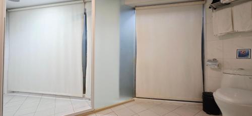 a glass shower door in a bathroom with a toilet at 喜園旅館Ximen Garden Inn in Taipei