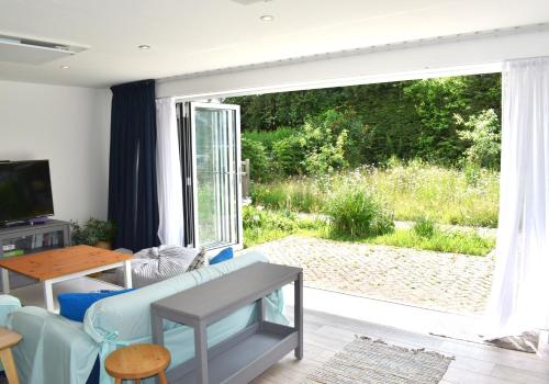 a living room with a large sliding glass door at Open Plan Dog Friendly Annexe Sleeping 2 I Near Local Beaches & Chichester with FREE Parking in Donnington