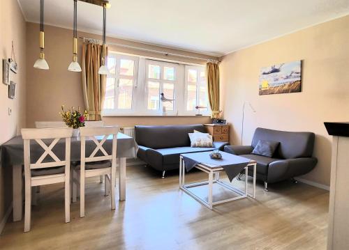 una sala de estar con un sofá y una mesa en Inselresidenz Strandburg Juist Ferienwohnung 50955, en Juist