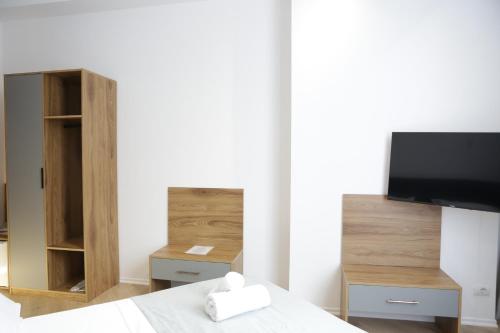 a bedroom with a bed with a tv and a cabinet at Hotel La Rosa in Tirane