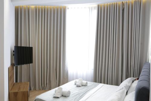 a bedroom with a bed with white towels on it at Hotel La Rosa in Tirane