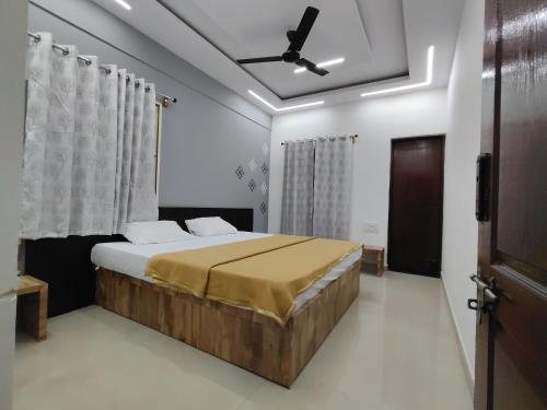 a bedroom with a bed and a ceiling fan at Nandan Suits in Mysore