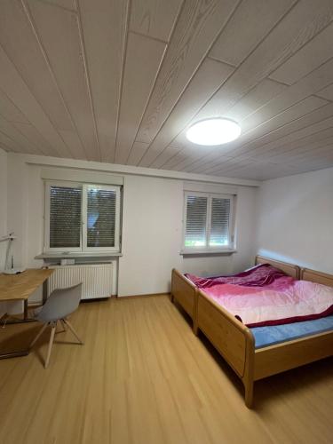 a bedroom with a bed and a desk and a table at Monteurzimmer oder WG Zimmervermietung in traumhafter Lage in Laufenburg