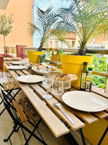 une table en bois avec des assiettes et des verres à vin dessus dans l'établissement Valras-Loc L-Hippocampe, tout a pied - 2 chambres, à Valras-Plage